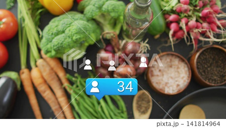 Displaying blue notification showing user icon 34 overlaying veggies and kitchenware on tabletop 141814964