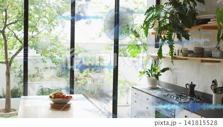 Showing bright kitchen with large glass panels opening onto small garden, with fruit bowl, stove Showing bright kitchen with large glass panels opening onto small garden, with fruit bowl, stove 141815528