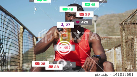 Drinking man in red top holding bottle on bridge with mesh rails, showing watch and overlays 141815691