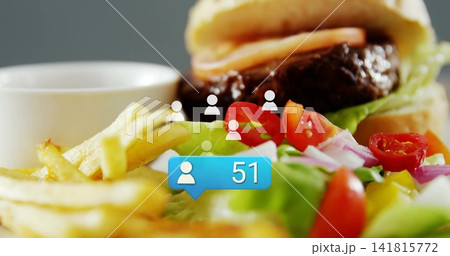 Showing burger with beef-patty, fries and salad on table, with blue '51' bubble and white-icons Showing burger with beef-patty, fries and salad on table, with blue '51' bubble and white-icons 141815772