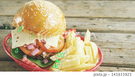 Showing sesame-bun burger with Swiss cheese, peppered fries in red-basket on table, CO2 overlay Showing sesame-bun burger with Swiss cheese, peppered fries in red-basket on table, CO2 overlay 141815925