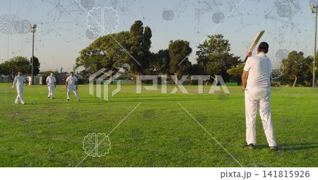 Swinging batsman with dark helmet and kit, raising cricket bat in park, neural overlays, copy space 141815926