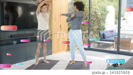 Stretching two men in workout clothes using mats in bright living room, with AR overlays Stretching two men in workout clothes using mats in bright living room, with AR overlays 141815928