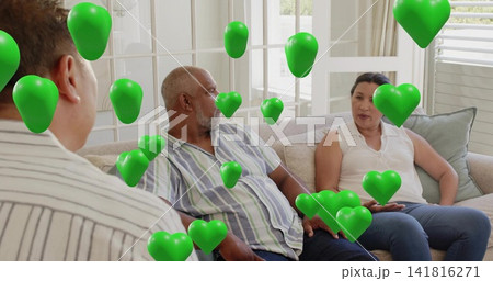 Sitting three adults talking on light sofa at home, woman in sleeveless top, floating green hearts 141816271