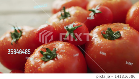 Showing cluster of ripe red tomatoes gleaming on wood counter, with green stems, drops, ID labels 141816386