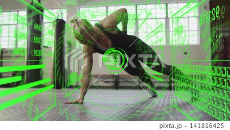 Mid-adult woman holding side-plank on padded gym floor in black tank and leggings, AR HUD overlay 141816425