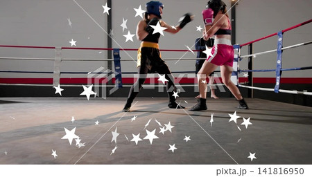 Punching left boxer wearing blue headgear and black top advancing in boxing ring, with white stars Punching left boxer wearing blue headgear and black top advancing in boxing ring, with white stars 141816950