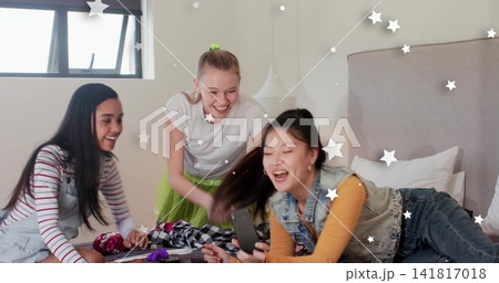 Reclining teen in mustard top, denim vest holding smartphone in bedroom, with clothes, copy space Reclining teen in mustard top, denim vest holding smartphone in bedroom, with clothes, copy space 141817018