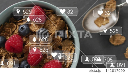 Displaying light-blue bowl of bran cereal with raspberries, blueberries on slate, spoon, UI alerts 141817090