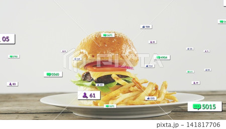 Showing stacked cheeseburger sitting on white ceramic plate with fries and floating social icons Showing stacked cheeseburger sitting on white ceramic plate with fries and floating social icons 141817706
