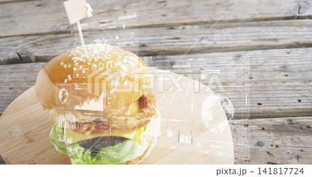 Showing cheeseburger on round cutting board on rustic table with flag toothpick, holographic data 141817724