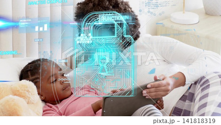 Reclining mom and daughter using tablet in bedroom, wearing white and pink tops, showing padlock Reclining mom and daughter using tablet in bedroom, wearing white and pink tops, showing padlock 141818319