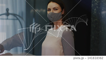 Standing masked woman in pink top facing camera at reception, showing DNA helix on glass partition Standing masked woman in pink top facing camera at reception, showing DNA helix on glass partition 141818382