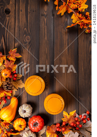 Autumn leaves and pumpkin drinks on wood background Autumn leaves and pumpkin drinks on wood background 141819618