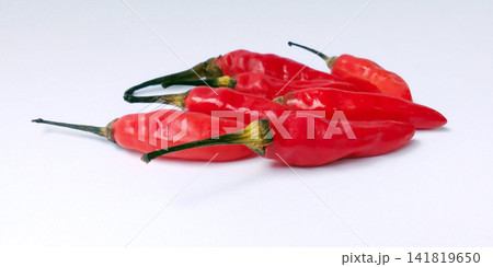 A pile of fresh red bird's eye chilies against a white background. A pile of fresh red bird's eye chilies against a white background. 141819650