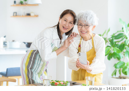家で料理を撮影するシニアの女性と友達 141820133