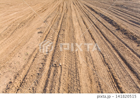 Texture brown yellow clay earth with traces of cars, trucks, tractors. Road with tire tracks. Texture brown yellow clay earth with traces of cars, trucks, tractors. Road with tire tracks. 141820515