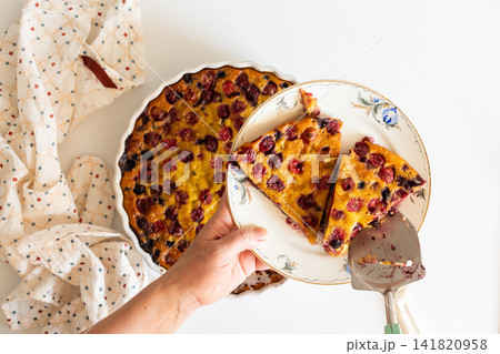 A woman slices a homemade cherry and currant pie, this pie combines cherry and currant flavors with sourdough for a delicious treat A woman slices a homemade cherry and currant pie, this pie combines cherry and currant flavors with sourdough for a delicious treat 141820958
