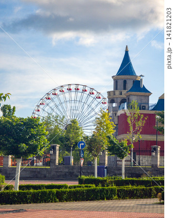 Ferris wheel and ornate tower with blue roofs Ferris wheel and ornate tower with blue roofs 141821203