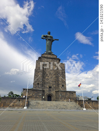 Iconic Mother Armenia Monument with outstretched arms atop stone base under bright sky 141821590