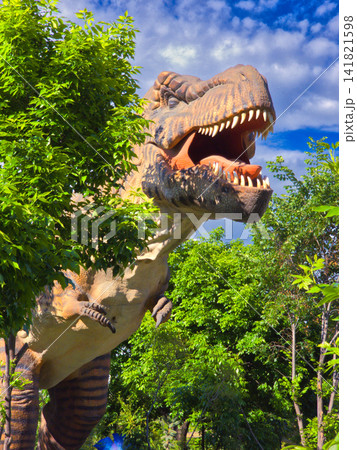 Tyrannosaurus rex statue amidst dense green trees 141821598