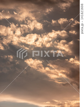Sunlight pierces through textured clouds during golden hour 141821608