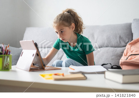 Schoolgirl using digital tablet for online learning at home Schoolgirl using digital tablet for online learning at home 141821840