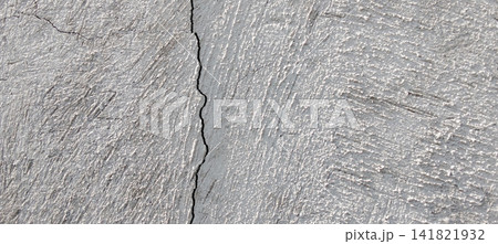 Vertical cracks on a light gray textured stucco surface. Vertical cracks on a light gray textured stucco surface. 141821932