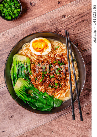 A bowl of noodles with minced meat, egg, and bok choy. A bowl of noodles with minced meat, egg, and bok choy. 141822568