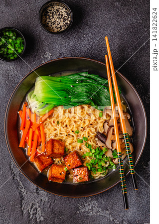 Noodles ramen miso soup served with tofu, bok choy, carrots, and mushrooms. 141822624