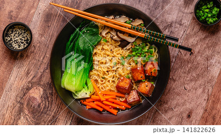 Noodles ramen miso soup served with tofu, bok choy, carrots, and mushrooms. 141822626
