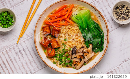 Noodles ramen miso soup served with tofu, bok choy, carrots, and mushrooms. Noodles ramen miso soup served with tofu, bok choy, carrots, and mushrooms. 141822629