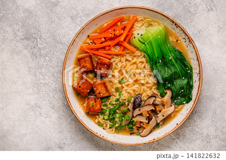 Noodles ramen miso soup served with tofu, bok choy, carrots, and mushrooms. Noodles ramen miso soup served with tofu, bok choy, carrots, and mushrooms. 141822632