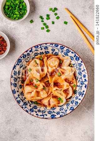 Wontons are placed in a bowl with spicy sauce. Wontons are placed in a bowl with spicy sauce. 141822660