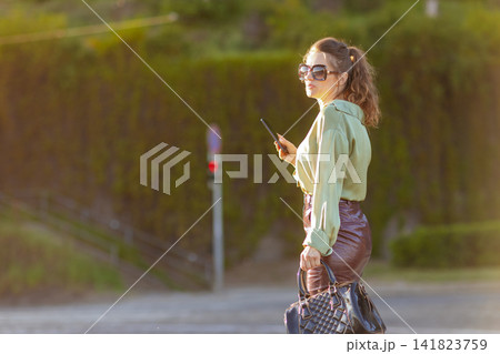 Confident Stylish Woman Looking Over Shoulder in the City 141823759