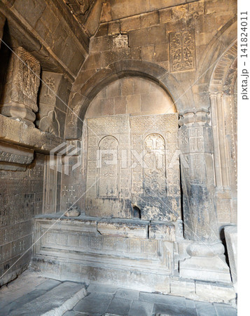 Weathered stone chapel featuring intricate carvings and arched entry Weathered stone chapel featuring intricate carvings and arched entry 141824011