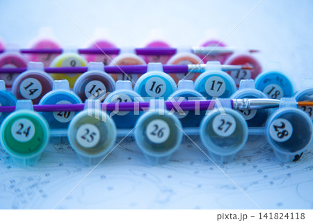 A low angle showing rows of numbered jars of acrylic paint, where the focus is on the middle numbers. Concept, variety of color palette, numbering system, detailed study, art. High quality photo 141824118