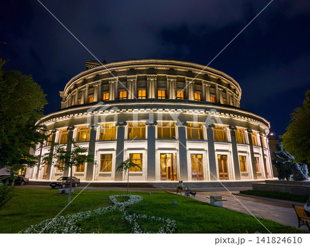 Beautiful, illuminated opera building at night with garden and statue 141824610