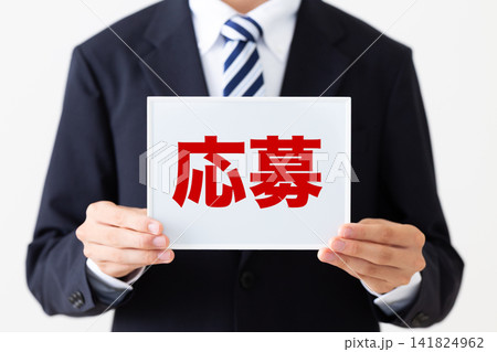 応募のホワイトボードを持つリクルートスーツを着た若い男性ビジネスマン 応募のホワイトボードを持つリクルートスーツを着た若い男性ビジネスマン 141824962