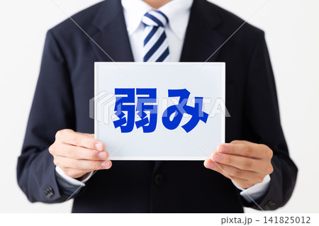 弱みのホワイトボードを持つリクルートスーツを着た若い男性ビジネスマン 弱みのホワイトボードを持つリクルートスーツを着た若い男性ビジネスマン 141825012