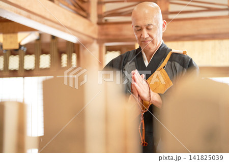 本堂で静かに祈る男性僧侶 141825039