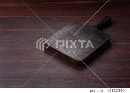 A square wooden cutting board for home food preparation. A wooden cutting board A square wooden cutting board for home food preparation. A wooden cutting board 141825304
