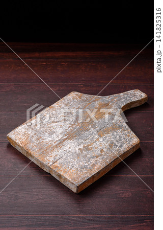 A square wooden cutting board for home food preparation. A wooden cutting board A square wooden cutting board for home food preparation. A wooden cutting board 141825316