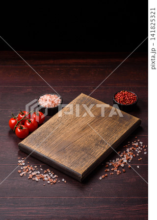A square wooden cutting board for home food preparation. A wooden cutting board A square wooden cutting board for home food preparation. A wooden cutting board 141825321
