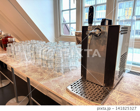 Drinking water dispenser with clean glasses on counter Drinking water dispenser with clean glasses on counter 141825327