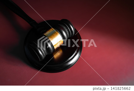 Wooden judge gavel on dark red burgundy gradient background with dramatic lighting, court and legal justice concept Wooden judge gavel on dark red burgundy gradient background with dramatic lighting, court and legal justice concept 141825662