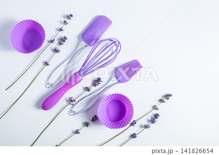 Kitchen tools and decorations arranged with lavender on a clean surface for baking tasks Kitchen tools and decorations arranged with lavender on a clean surface for baking tasks 141826654