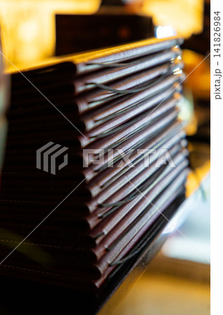 menu at a restaurant table. Stack of menu in leather cover, menus laying on the table. menu at a restaurant table. Stack of menu in leather cover, menus laying on the table. 141826984