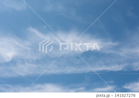 Light white cirrus clouds create a soft airy pattern against a clear blue summer sky. Light white cirrus clouds create a soft airy pattern against a clear blue summer sky. 141827276