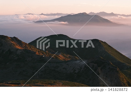 ご来光の光が山並みの層を照らす高山の朝景 141828872